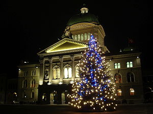 The parliament building in Bern, Switzerland with the Christmas tree by night