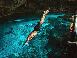 A man jumping into Cancun's famous cenotes