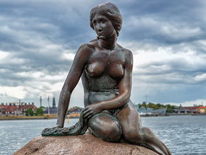 A statue of a mermaid sitting on a rock, surrounded by water in Copenhagen, Denmark (© Avda-berlin, CC BY-SA 3.0)