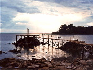A small jetty into Lake Malawi at Nkhata Bay, northern Malawi. Three fishermen in two canoes are heading home for the evening, to the town's main beach 100 m ahead of them. (© JackyR, CC BY-SA 3.0)