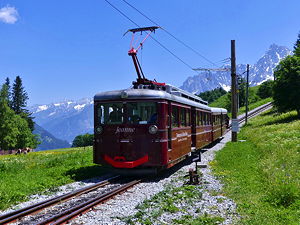 The Jeanne red locomotive of Tramway du Mont-Blanc (TMB) touristic rack railway to the Mont-Blanc, arriving from the Nid d'Aigle at Col de Voza station, Haute-Savoie, France. (© Florian Pépellin, CC BY-SA 4.0)