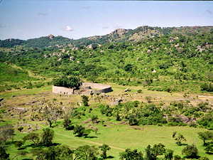Overview of Great Zimbabwe. The large walled construction is the Great Enclosure. Some remains of the valley complex can be seen in front of it.